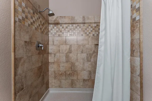 a bathroom with a shower and a bath tub
