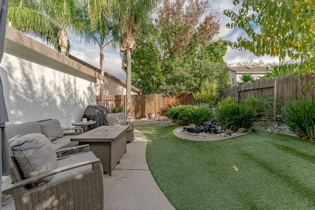 a view of a house with backyard sitting area and garden