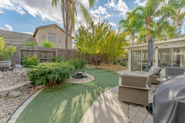 a view of a house with backyard sitting area and garden