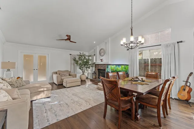 a view of a dining room with furniture a chandelier and wooden floor