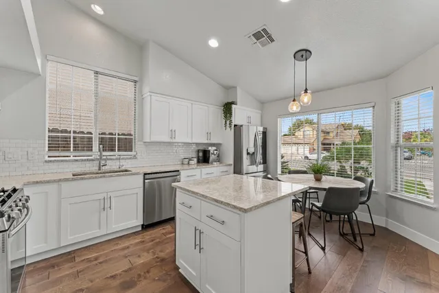 a kitchen with a stove center island and windows