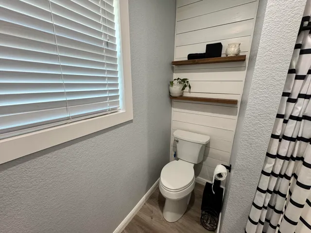 a white toilet sitting next to a shower curtain