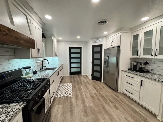 a kitchen with stainless steel appliances granite countertop a stove and a refrigerator