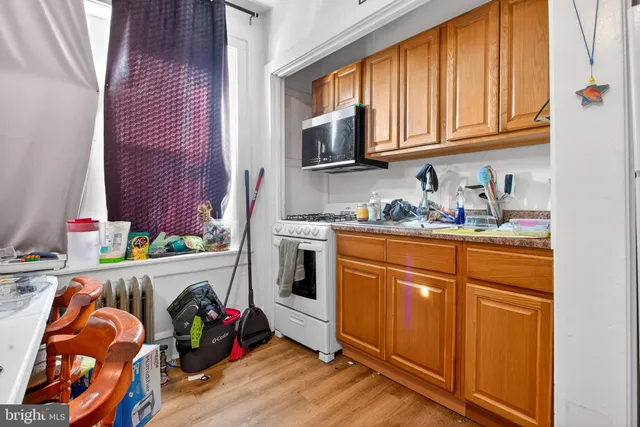 a kitchen with stainless steel appliances granite countertop a sink dishwasher stove and cabinets with wooden floor