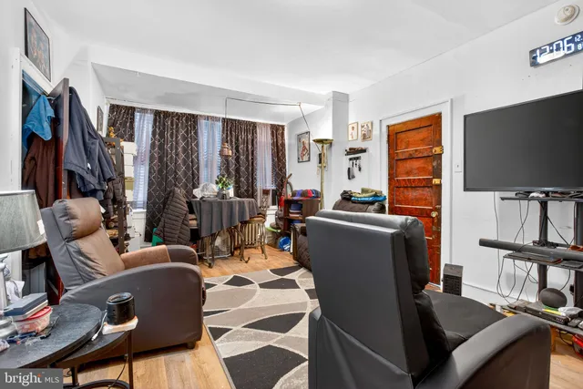 a living room with furniture a flat screen tv and a window