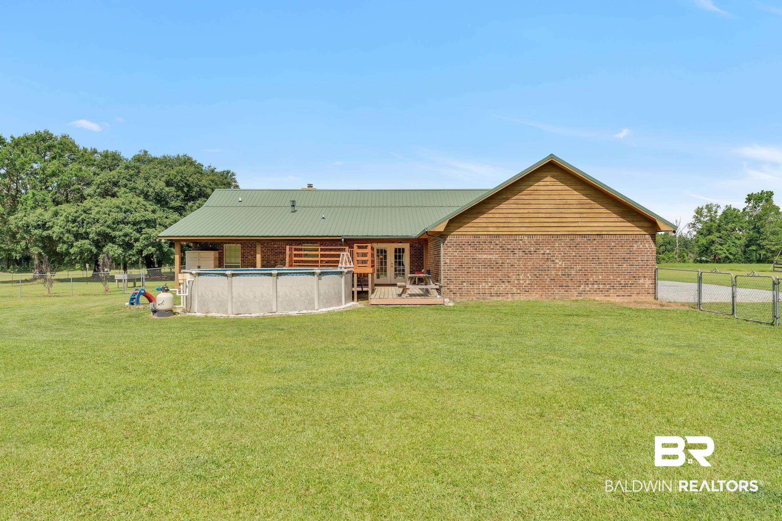 4062 River Road Theodore, AL 36582 - Photo 11 of 32 Back of property featuring french doors, an outdoor pool, metal roof, and brick siding