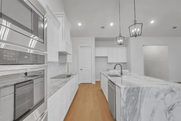 a spacious kitchen with stainless steel appliances granite countertop a sink stove and refrigerator