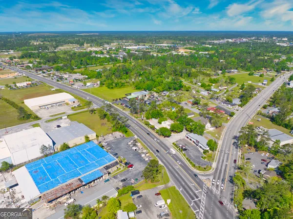 an aerial view of a city with lots of residential buildings ocean and mountain view in back