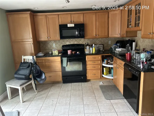 a kitchen with granite countertop a refrigerator stove and cabinets