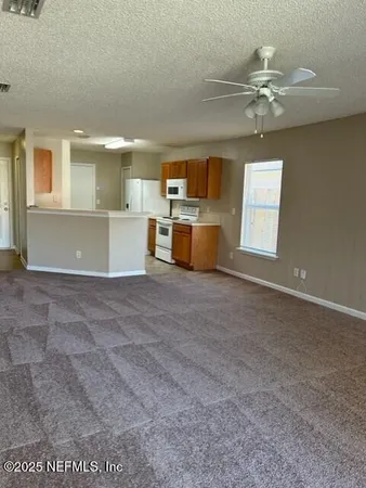 a kitchen with stainless steel appliances a sink a stove a refrigerator cabinets and a window