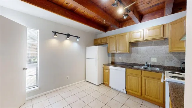 a kitchen with stainless steel appliances granite countertop a sink and a refrigerator