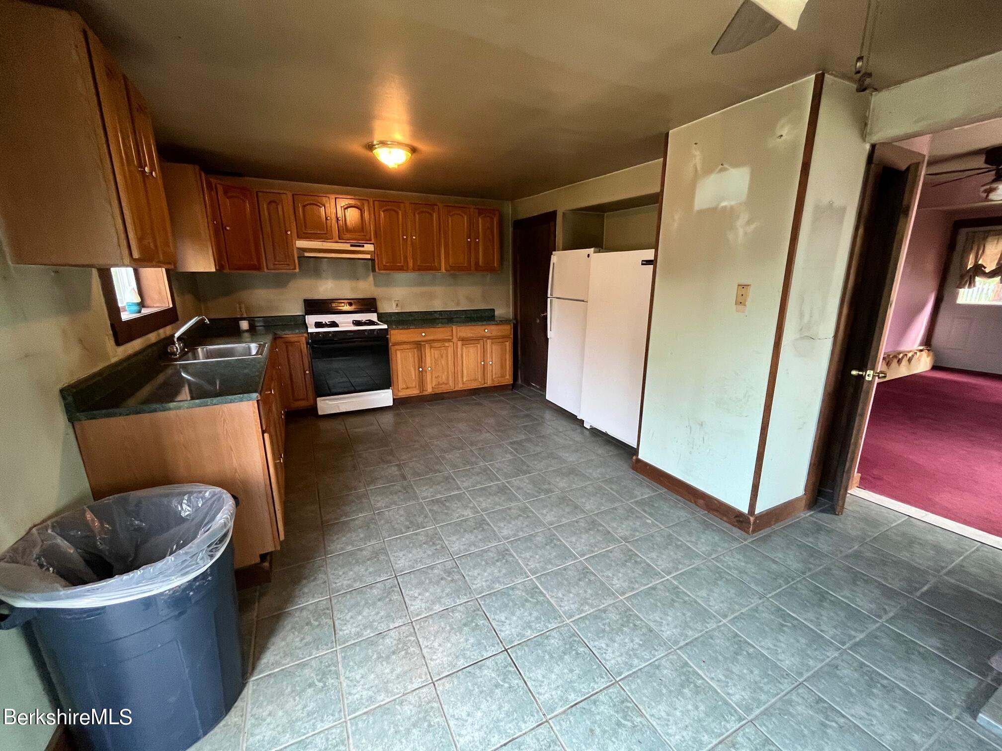 21 Ray Street North Adams, MA 01247 - Photo 5 of 27 a kitchen with stainless steel appliances a refrigerator a sink a stove top oven a counter space and cabinets