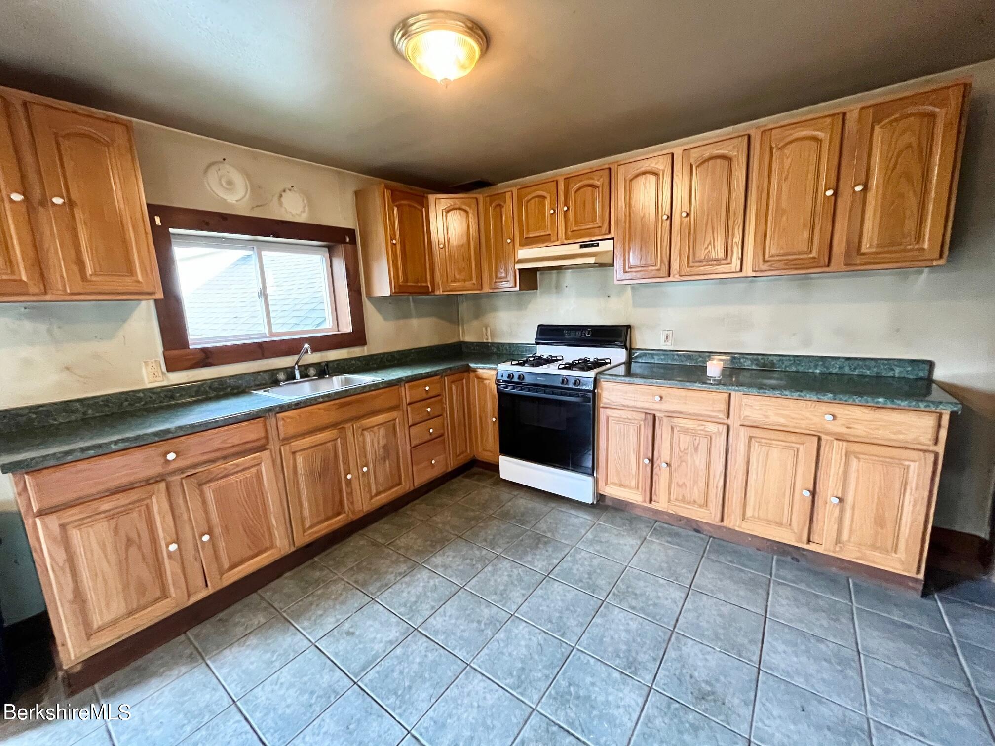 21 Ray Street North Adams, MA 01247 - Photo 6 of 27 a kitchen with stainless steel appliances granite countertop a stove sink and cabinets