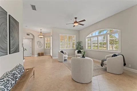 a living room with furniture kitchen view and a chandelier