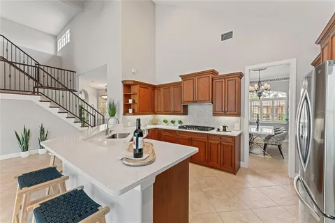 a living room with furniture kitchen view and a chandelier