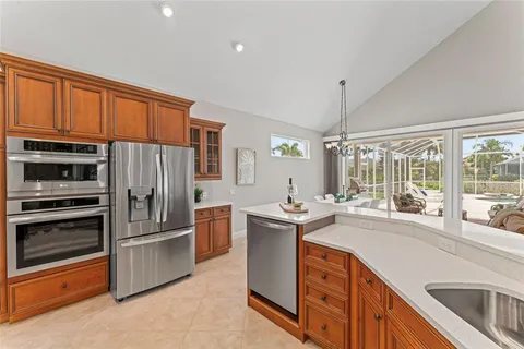 a kitchen with stainless steel appliances kitchen island granite countertop a sink and a refrigerator