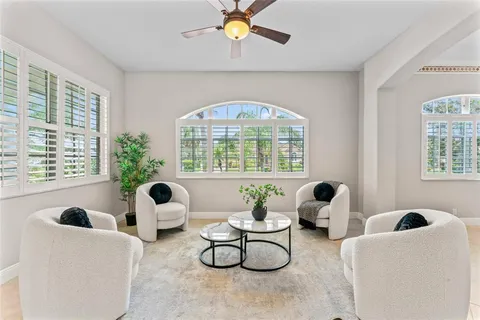 a living room with furniture a chandelier and a large window