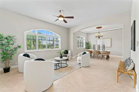 a living room with furniture a chandelier and a large window