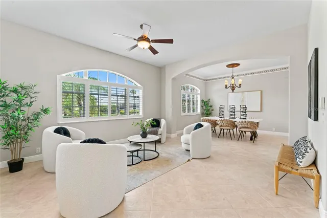 a living room with furniture a chandelier and a large window