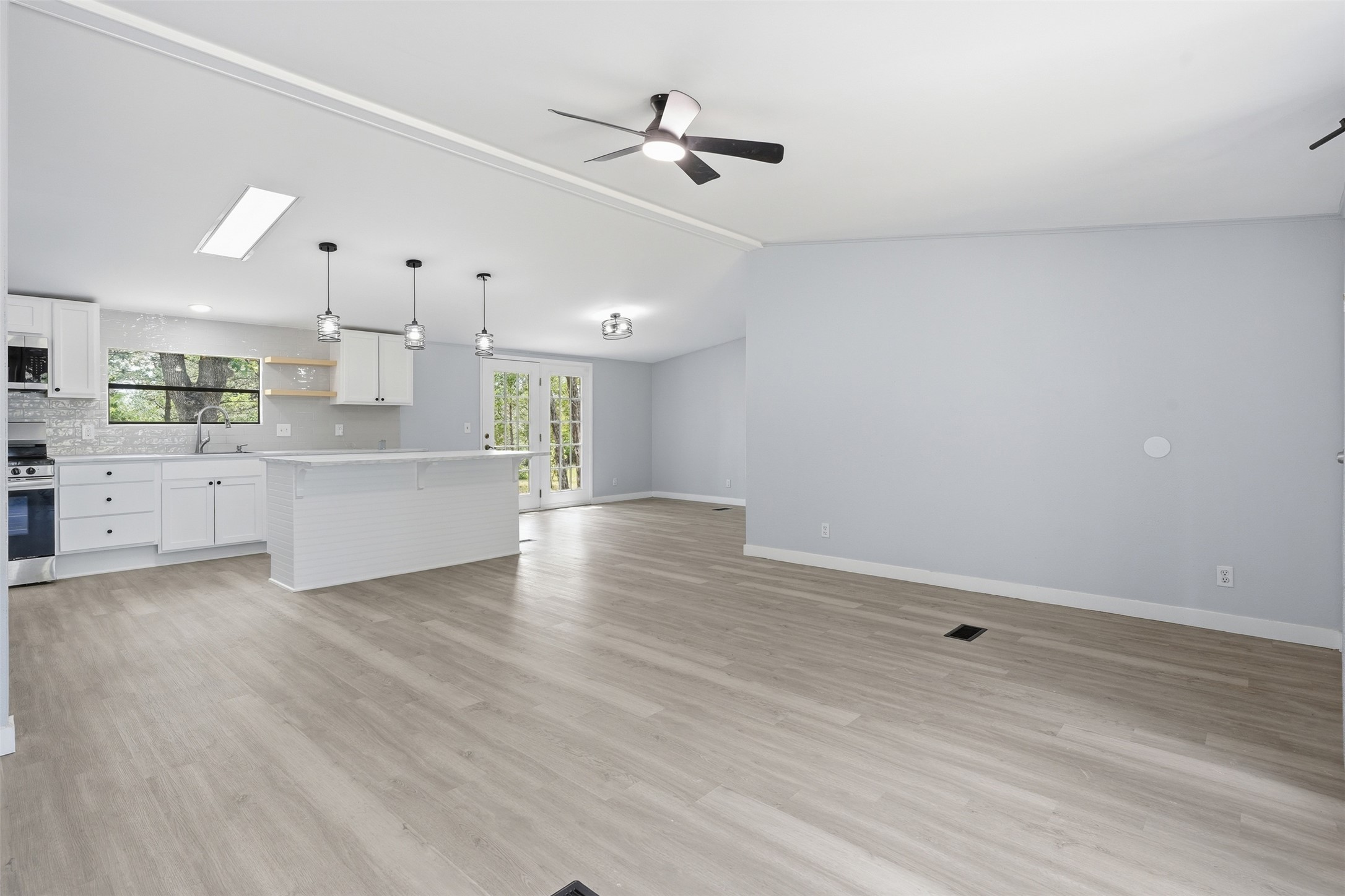 154 Antioch Road Smithville, TX 78957 - Photo 4 of 32 An open-concept living area boasts light wood flooring and a kitchen island for seamless entertaining.