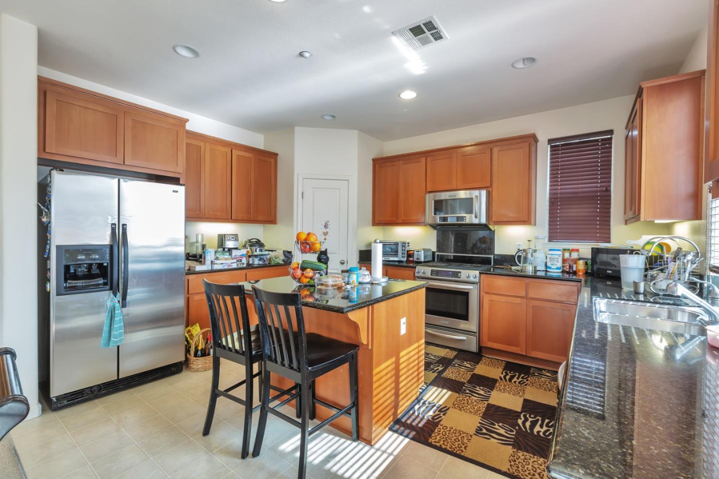 22860 Mono Street Hayward, CA 94541 - Photo 5 of 26 a kitchen with stainless steel appliances granite countertop a stove a sink dishwasher a refrigerator with a dining table and chairs with wooden floor