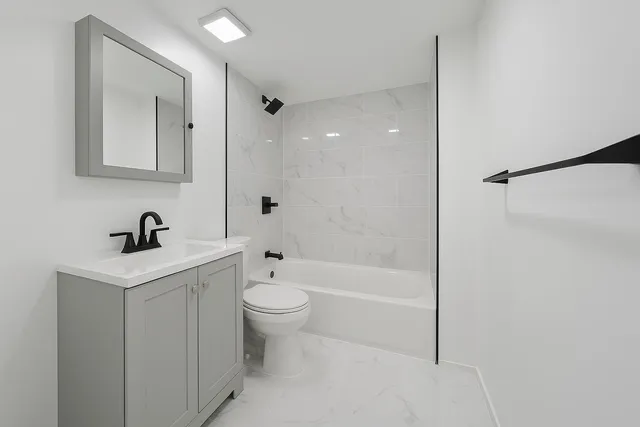 a bathroom with a sink a toilet and shower