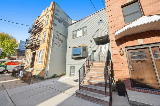 a view of a building with car parked on the road
