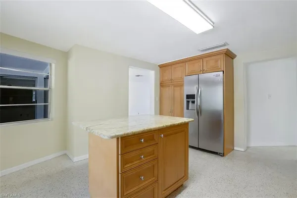 a kitchen with stainless steel appliances granite countertop a refrigerator and a stove