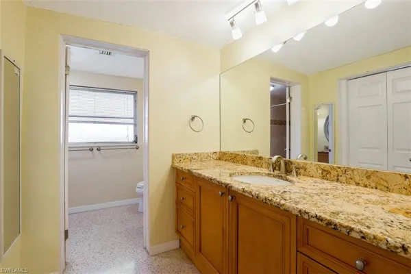 a bathroom with a granite countertop sink and a mirror