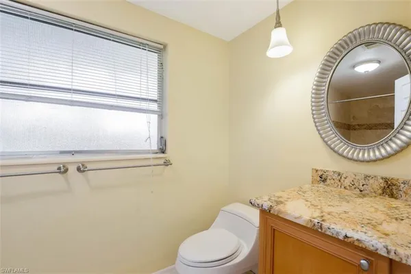 a bathroom with a toilet a sink and mirror