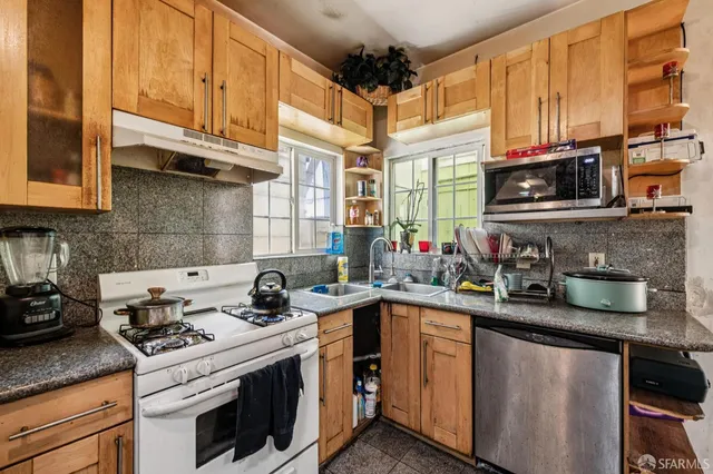 a kitchen with stainless steel appliances granite countertop a sink stove and microwave