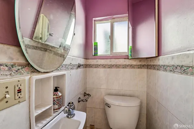 a bathroom with a toilet a sink and a mirror