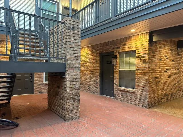 a front view of a building with a door and an outdoor space