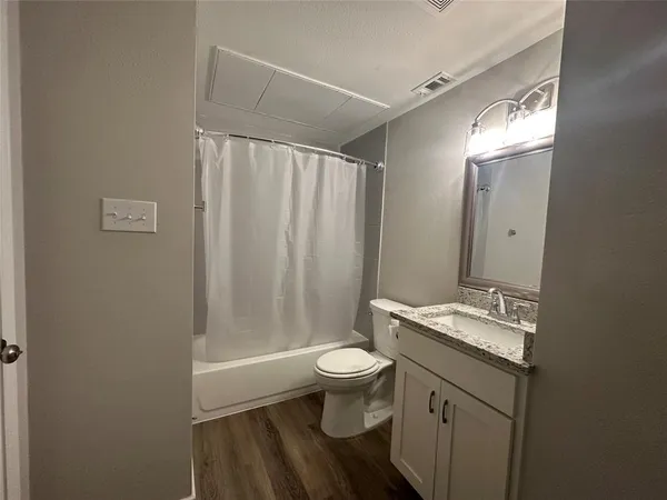 a bathroom with a granite countertop sink toilet and shower