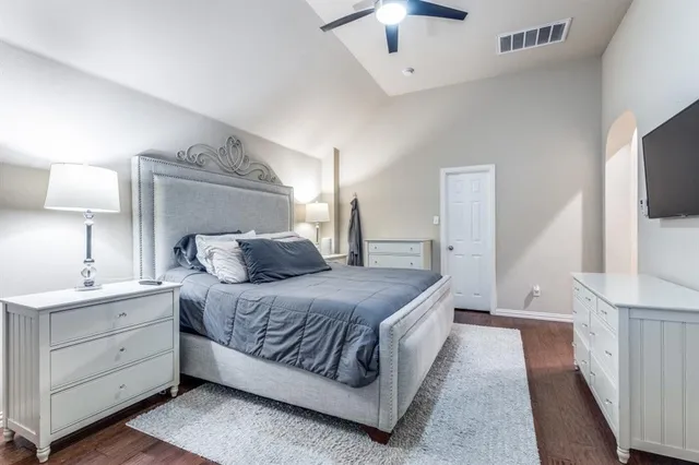 a bedroom with a bed and a flat tv screen on dresser