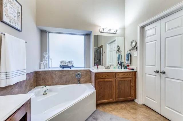 a en suite bathroom with a tub a sink and mirror