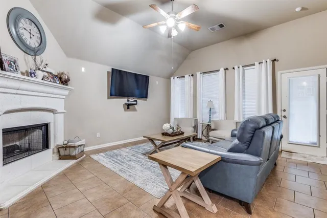 a living room with furniture a fireplace and a flat screen tv