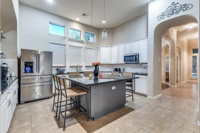 a kitchen with stainless steel appliances kitchen island granite countertop a sink and cabinets