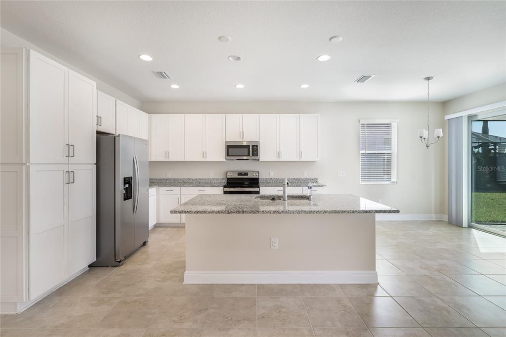 19803 Bridgetown Loop Venice, FL 34293 - Photo 15 of 51 a large kitchen with stainless steel appliances granite countertop a refrigerator a stove a sink and a microwave