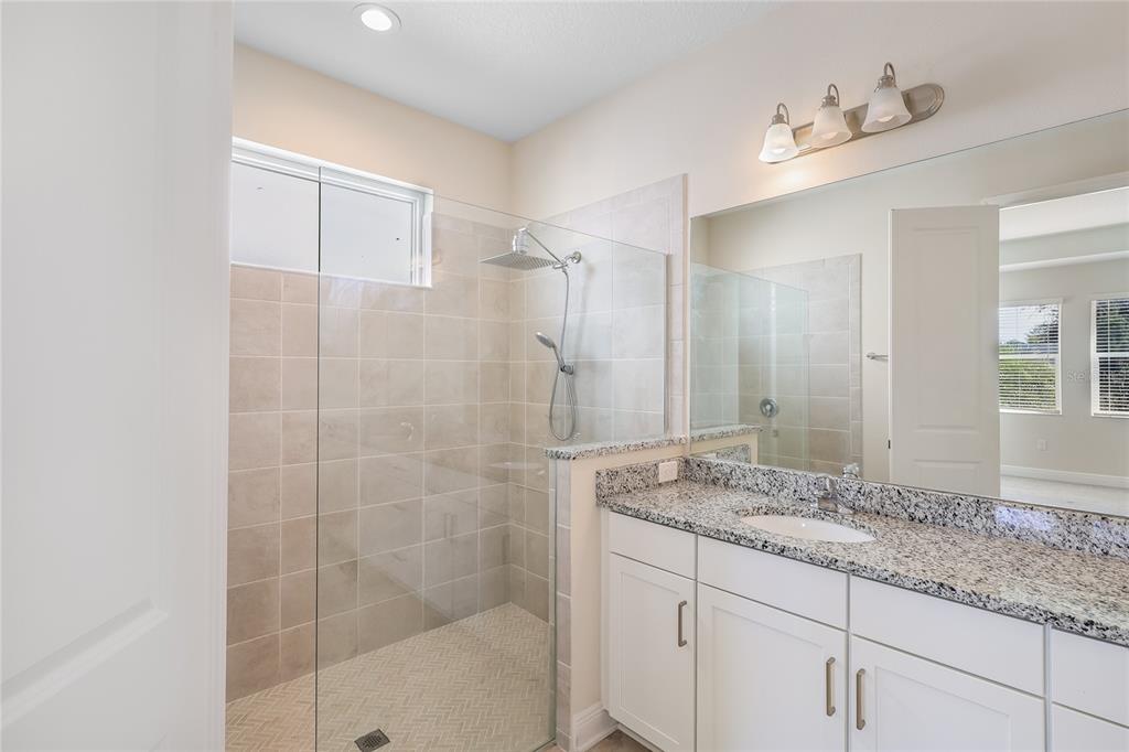 19803 Bridgetown Loop Venice, FL 34293 - Photo 21 of 51 a bathroom with a granite countertop sink a mirror and shower