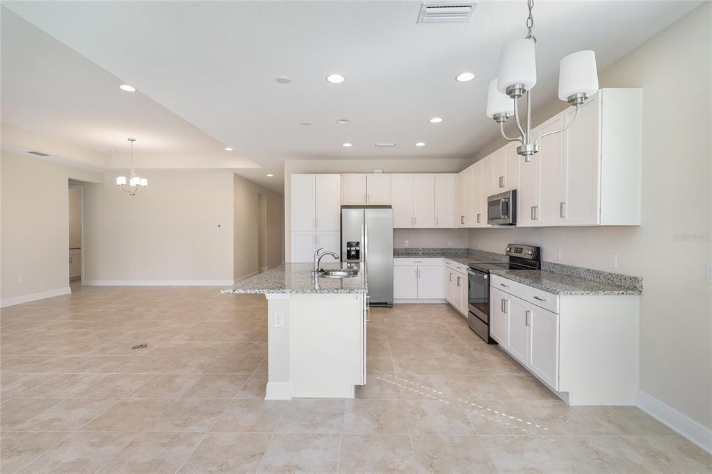 19803 Bridgetown Loop Venice, FL 34293 - Photo 27 of 51 a large white kitchen with lots of counter space wooden floor and appliances