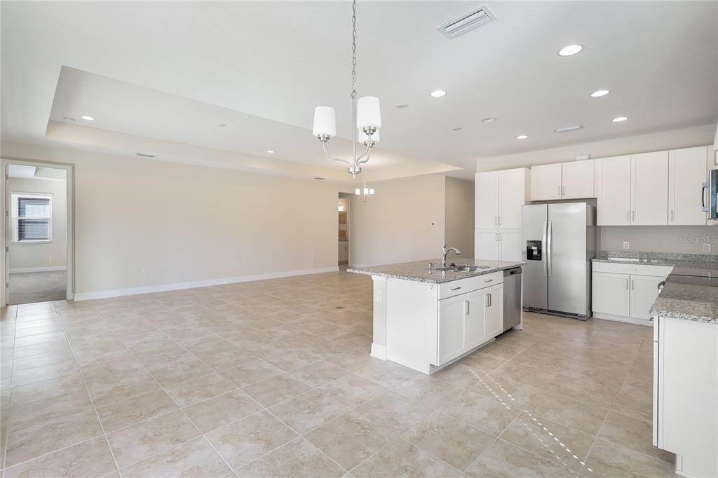 19803 Bridgetown Loop Venice, FL 34293 - Photo 33 of 51 a large kitchen with granite countertop a white stove a sink and a refrigerator