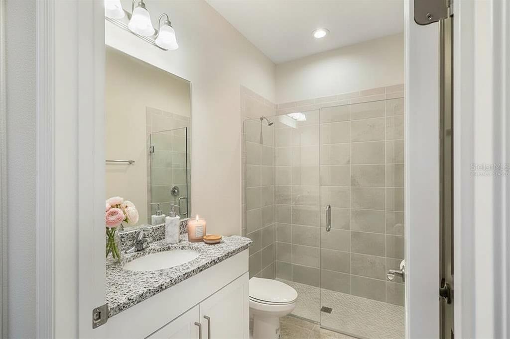 19803 Bridgetown Loop Venice, FL 34293 - Photo 50 of 51 a bathroom with a granite countertop sink a toilet and shower