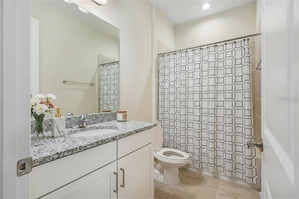 19803 Bridgetown Loop Venice, FL 34293 - Photo 51 of 51 a bathroom with a granite countertop sink a toilet and mirror