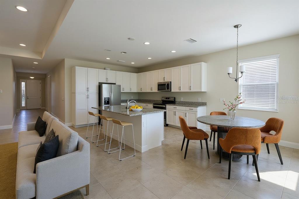 19803 Bridgetown Loop Venice, FL 34293 - Photo 8 of 51 a living room with stainless steel appliances kitchen island granite countertop furniture and a view of kitchen