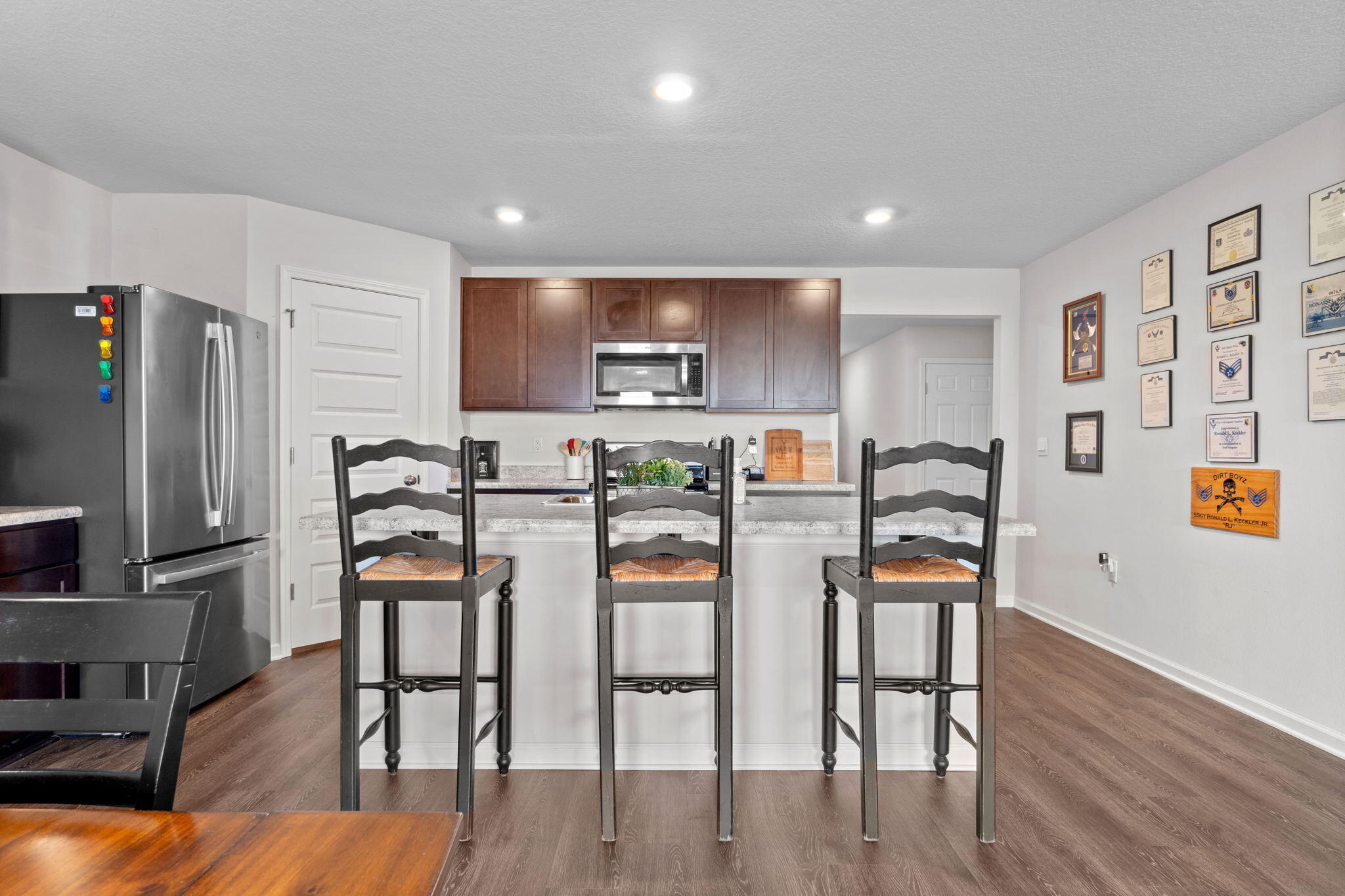 209 Laurel Hill Street Crestview, FL 32539 - Photo 15 of 43 a kitchen with stainless steel appliances wooden floor and chairs