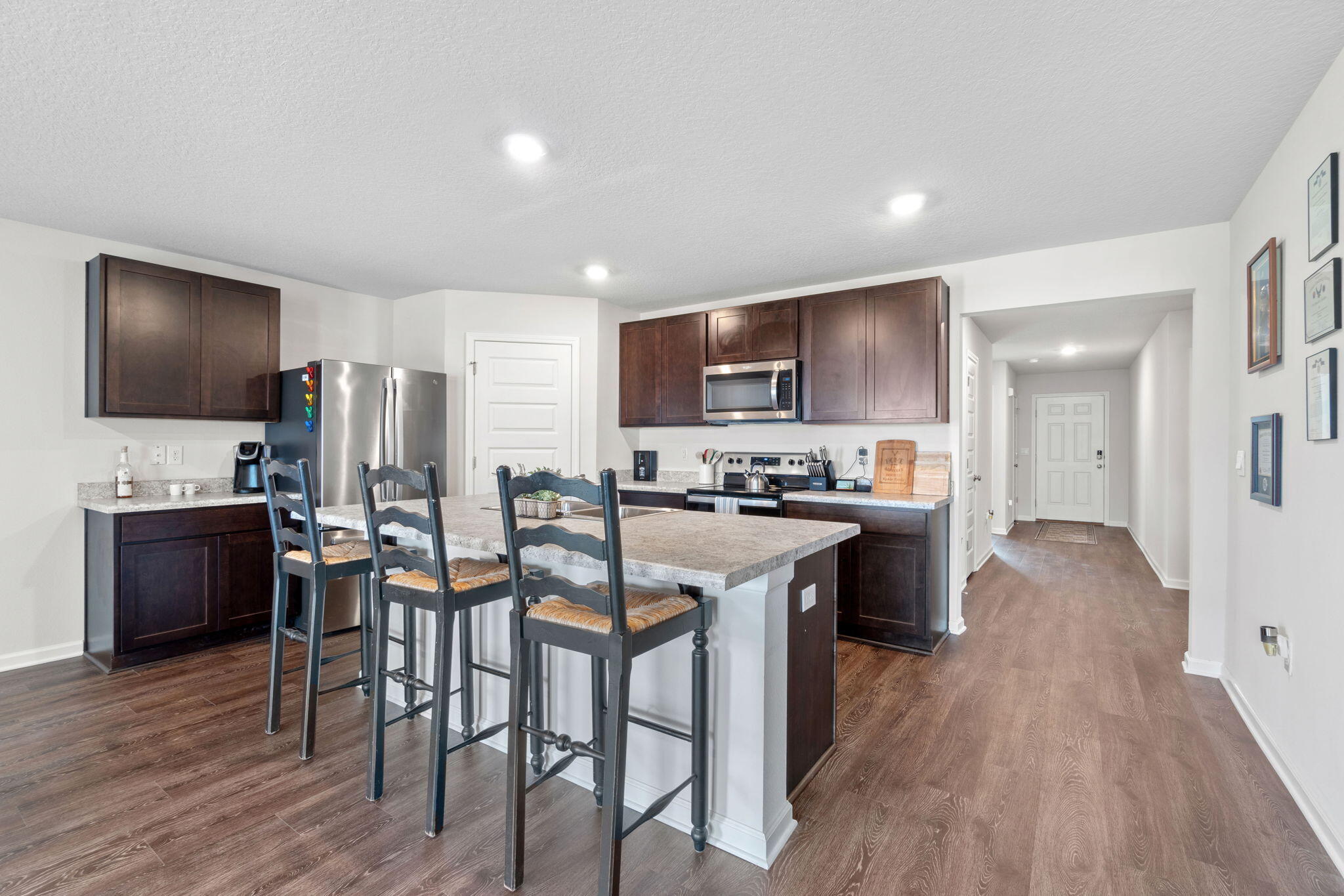 209 Laurel Hill Street Crestview, FL 32539 - Photo 8 of 43 a kitchen with stainless steel appliances a stove a sink a refrigerator and a dining table with wooden floor