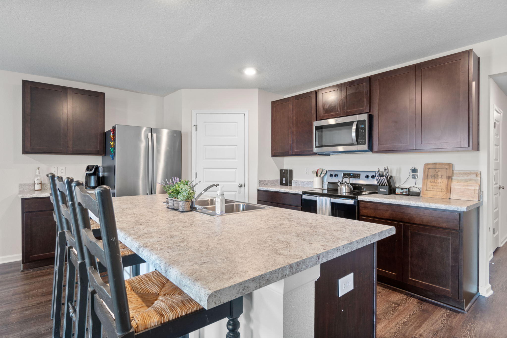209 Laurel Hill Street Crestview, FL 32539 - Photo 9 of 43 a kitchen with a stove a sink a microwave a dining table and chairs