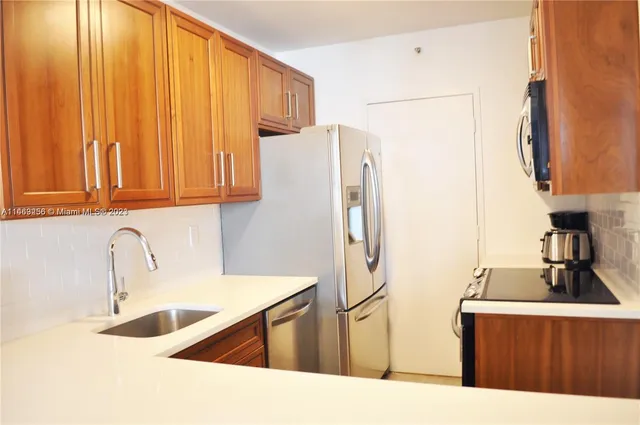 a kitchen with stainless steel appliances a sink and a refrigerator
