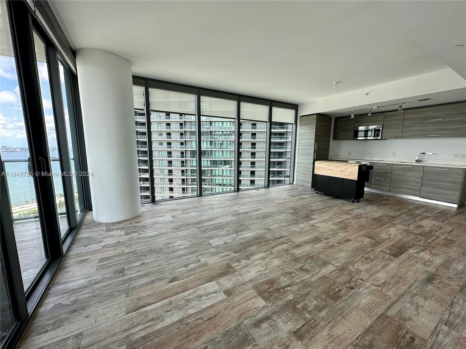Edgewater Miami, FL 33137 - Photo 4 of 13 an empty room with wooden floor and windows